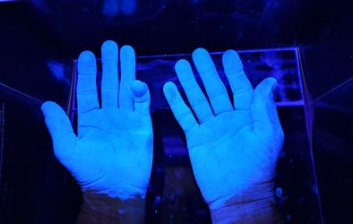 Razkužene roke pod UV svetlobo